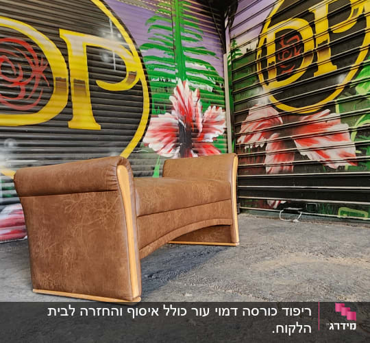 ספה חומה על רצפת בטון עם גרפיטי צבעוני ברקע